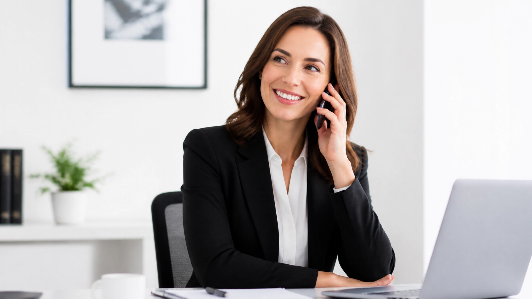 A professional woman talking on a phone in a bright office, representing our helpful and personal service.