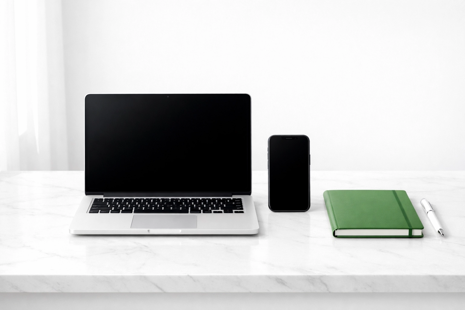 Clean office desk with a laptop and phone showing integrated digital services for small business owners.